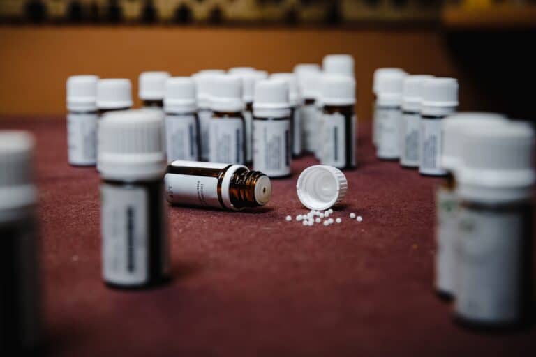 Closeup shot of small glass bottles of pills on the table under the lights - medical concept